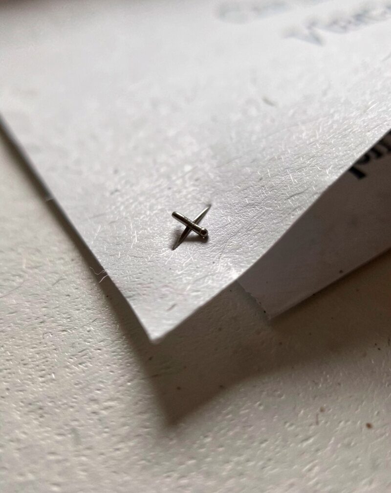 A clipboard lying face-down on a car dashboard so only its blank metal clip and board back show